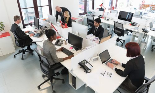 Elevated view of multiracial business people at their desk working in office. Horizontal shot.